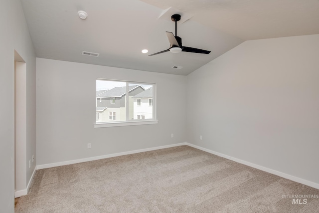 carpeted spare room featuring ceiling fan and lofted ceiling