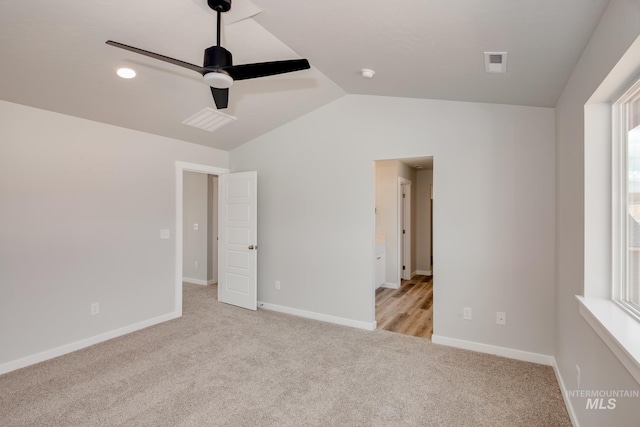 unfurnished bedroom with ceiling fan, light colored carpet, and vaulted ceiling