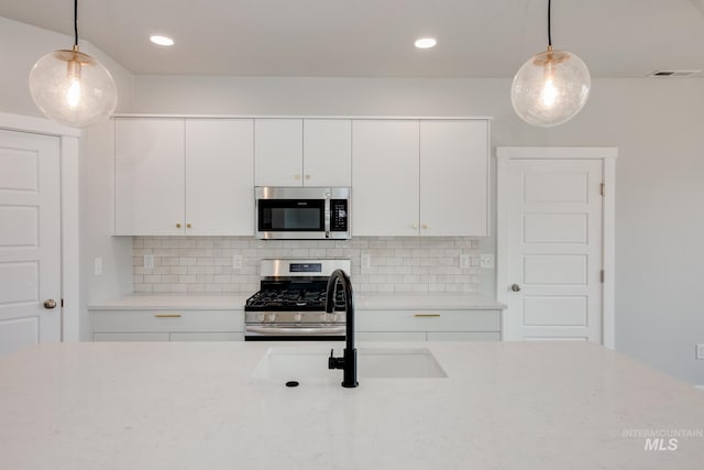 kitchen featuring pendant lighting, white cabinetry, and stainless steel appliances