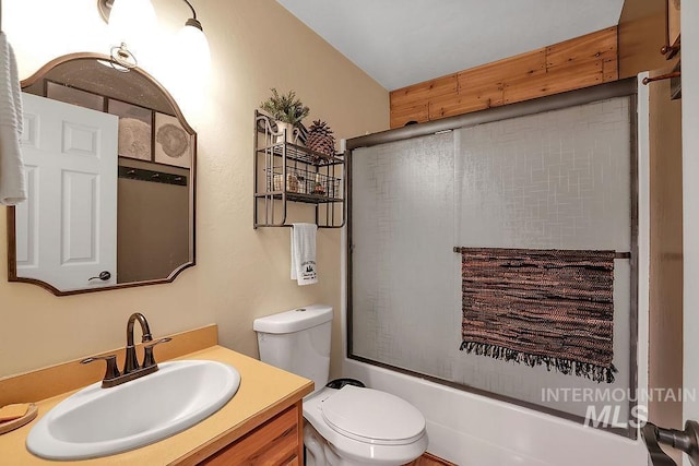 full bathroom featuring vanity, bath / shower combo with glass door, and toilet