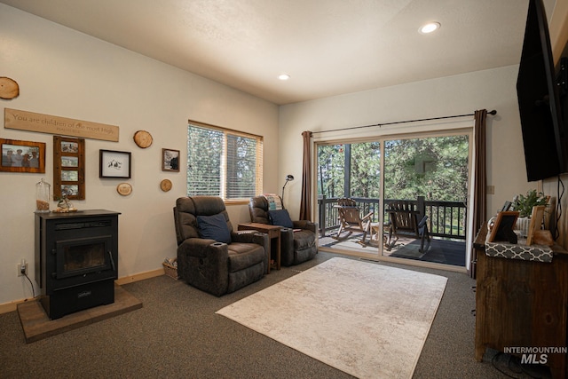 living room with dark colored carpet and a wood stove