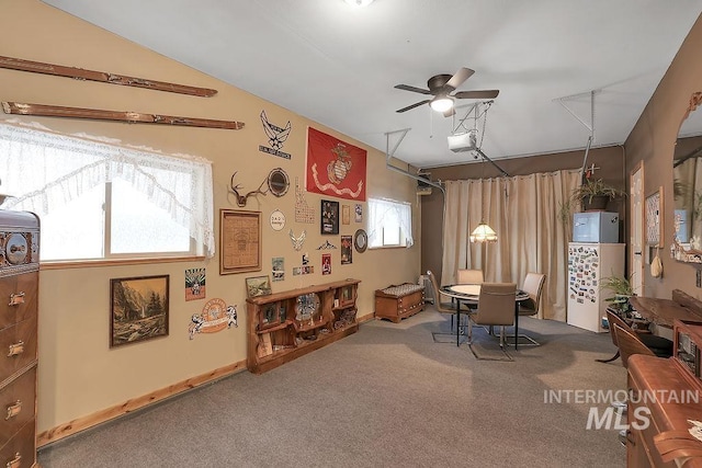 carpeted dining space with ceiling fan