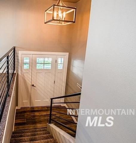 entryway with a chandelier and dark wood finished floors