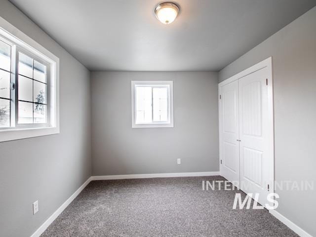 unfurnished bedroom featuring carpet flooring, baseboards, and a closet
