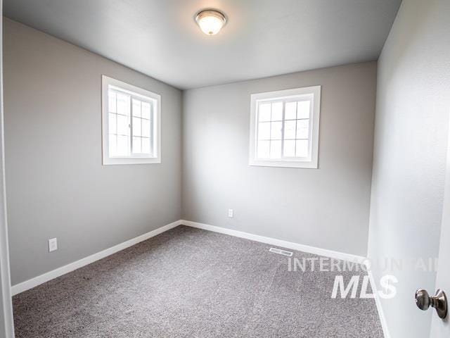 unfurnished room with carpet floors and baseboards