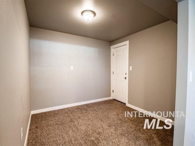 empty room featuring carpet and baseboards