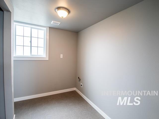 carpeted spare room featuring baseboards