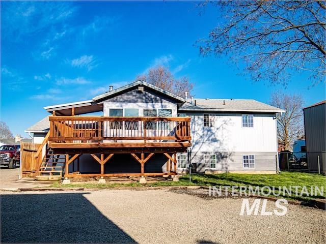 back of house with a deck, fence, and stairway