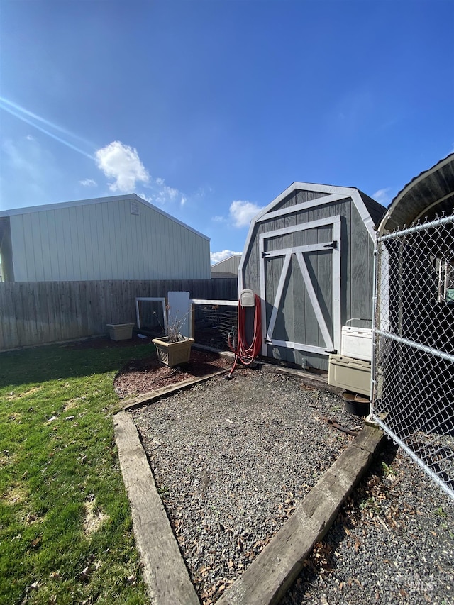 view of yard featuring an outbuilding, fence, and a shed