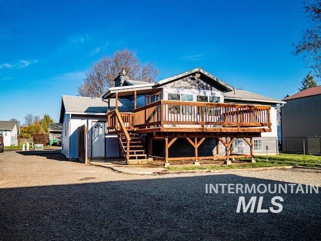 back of property featuring stairs, a wooden deck, a chimney, and fence