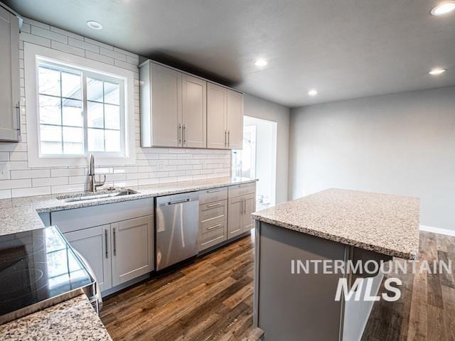 kitchen with dishwasher, a sink, dark wood-style floors, recessed lighting, and decorative backsplash