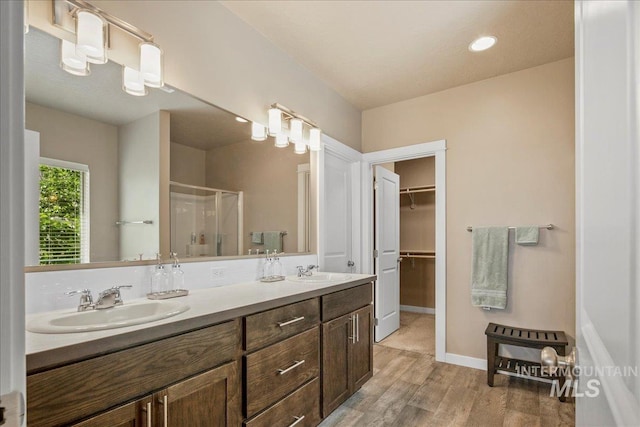 2510 Duchess Trl, Emmett, ID 83617 - bathroom with a stall shower, double vanity, wood finished floors, a walk in closet, and baseboards