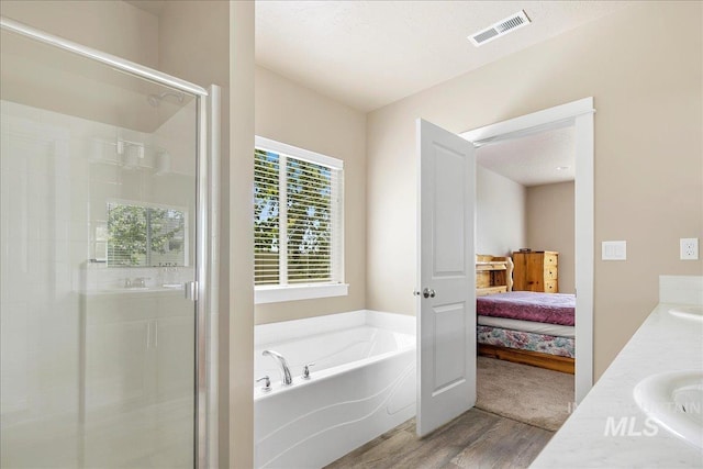 2510 Duchess Trl, Emmett, ID 83617 - ensuite bathroom featuring wood finished floors, a bath, a shower stall, and double vanity