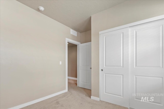 2510 Duchess Trl, Emmett, ID 83617 - unfurnished bedroom featuring light carpet, baseboards, a closet, and a textured ceiling