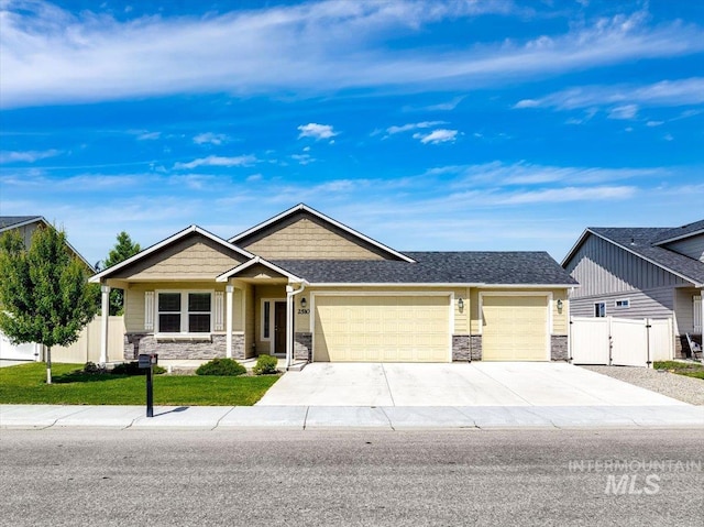 2510 Duchess Trl, Emmett, ID 83617 - craftsman-style house featuring stone siding, a garage, driveway, a gate, and a shingled roof