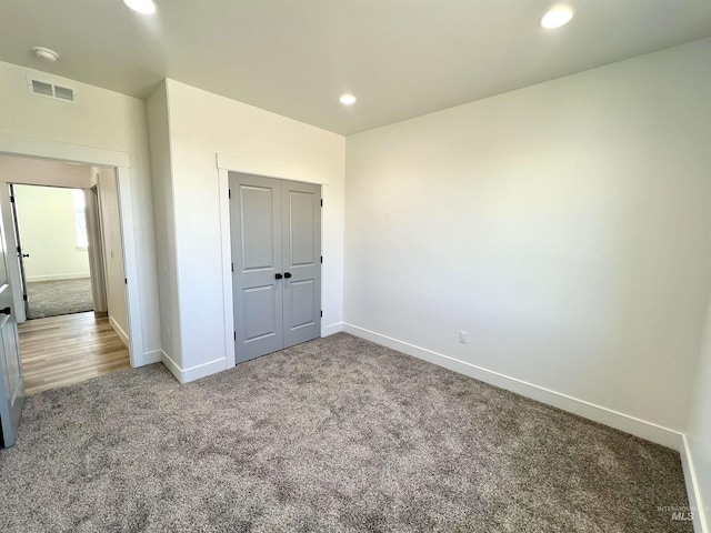 unfurnished bedroom with recessed lighting, carpet floors, visible vents, and baseboards