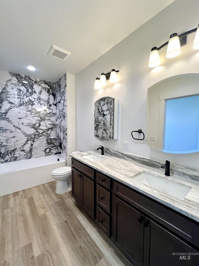 full bathroom featuring wood finished floors, visible vents, toilet, and a sink