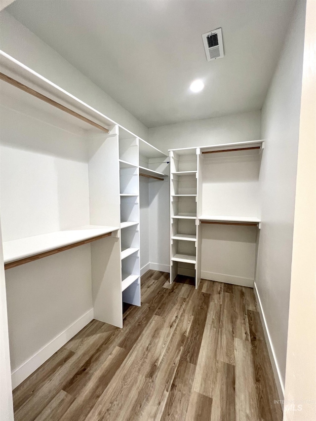 walk in closet with wood finished floors and visible vents