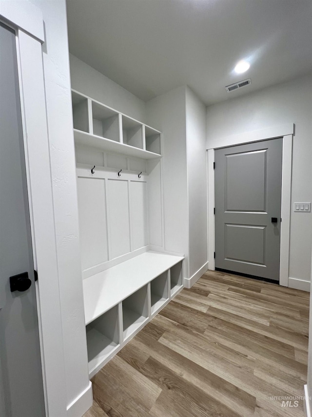 mudroom featuring baseboards, wood finished floors, and visible vents