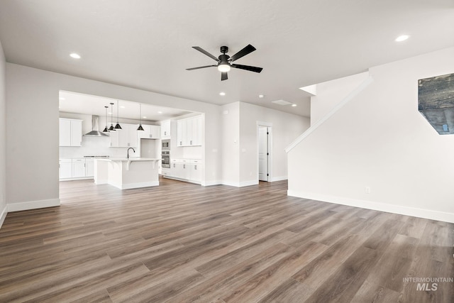 6117 N Torva Ave, Meridian, ID 83646 - unfurnished living room featuring a ceiling fan, recessed lighting, wood finished floors, baseboards, and a sink