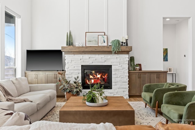 living area featuring light wood-style flooring and a fireplace