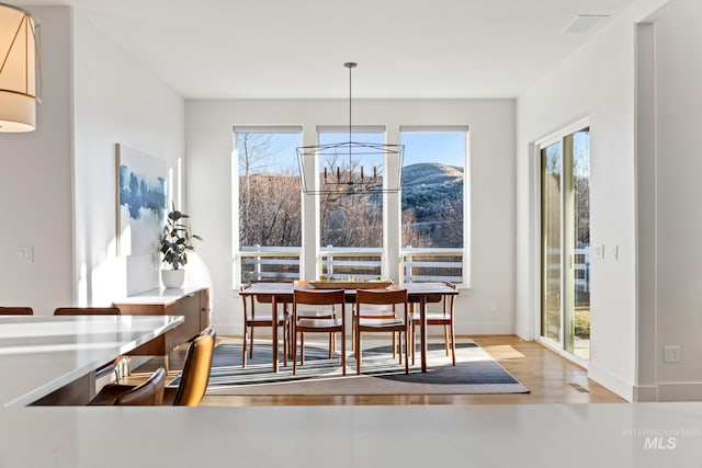 dining space featuring visible vents, plenty of natural light, baseboards, and wood finished floors