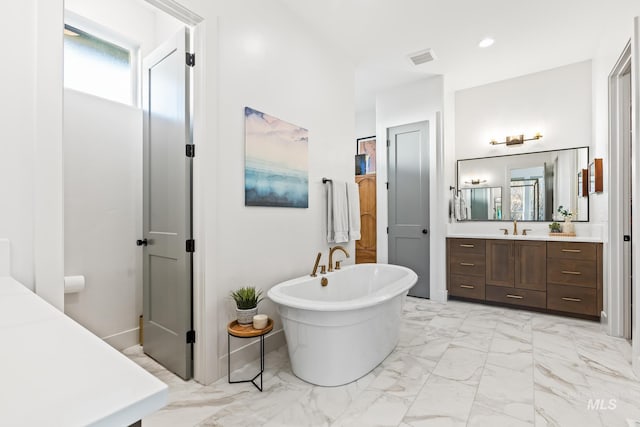 bathroom featuring marble finish floor, recessed lighting, visible vents, vanity, and a freestanding tub