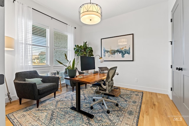 office area featuring light wood-type flooring and baseboards