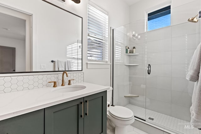 full bath with toilet, a shower stall, vanity, and decorative backsplash