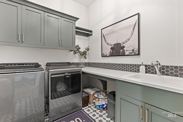 laundry room featuring independent washer and dryer, a sink, and cabinet space