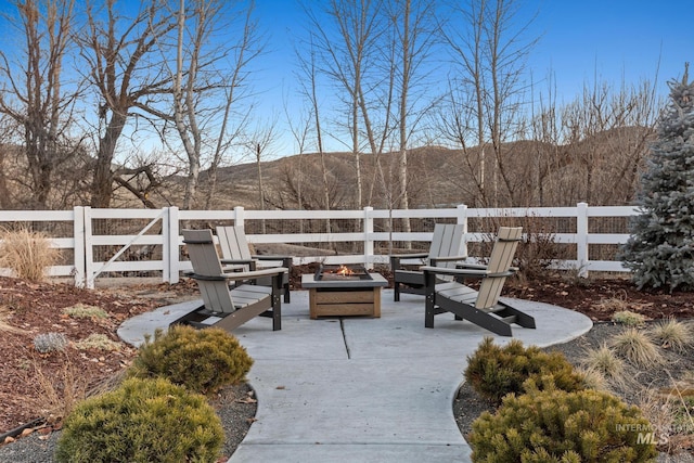 exterior space featuring a fire pit, a patio area, fence, and a mountain view