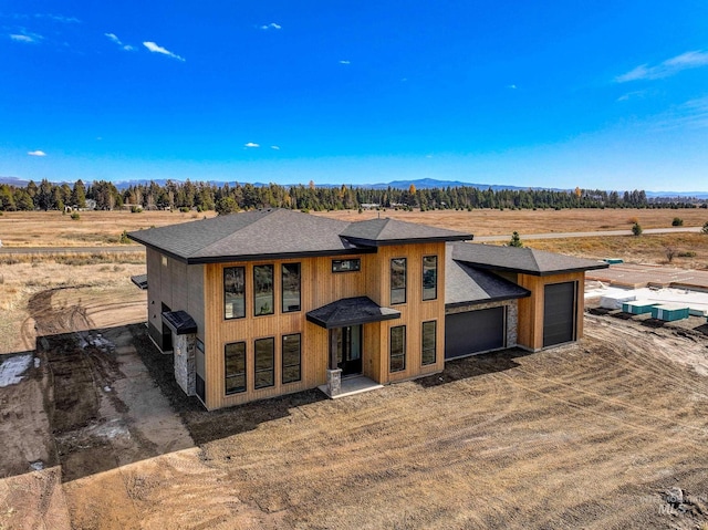 view of front of property with a rural view and a garage