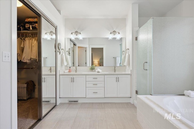 5322 N Papago Pl, Boise, ID 83713 - bathroom featuring double vanity, a shower stall, a garden tub, and a walk in closet