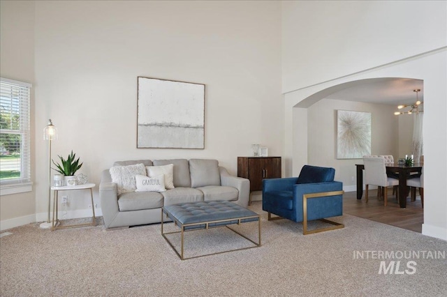 5322 N Papago Pl, Boise, ID 83713 - living room featuring arched walkways, a chandelier, carpet floors, and a high ceiling