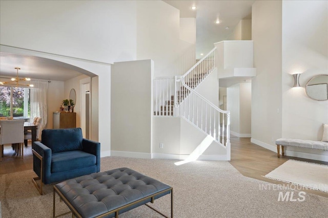 5322 N Papago Pl, Boise, ID 83713 - living area featuring arched walkways, a chandelier, carpet flooring, a high ceiling, and stairway