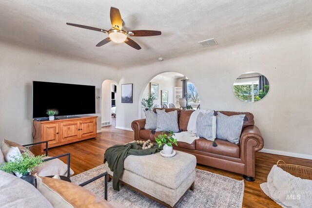 2524 Succor Creek Rd, Homedale, ID 83628 - living room featuring arched walkways, a ceiling fan, wood finished floors, and baseboards