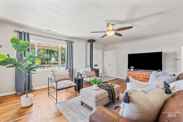 2524 Succor Creek Rd, Homedale, ID 83628 - living area featuring a wood stove, a ceiling fan, wood finished floors, and baseboards