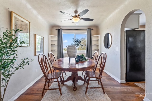2524 Succor Creek Rd, Homedale, ID 83628 - dining space featuring arched walkways, ceiling fan, a textured wall, wood finished floors, and baseboards