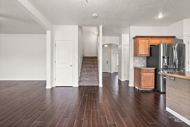 1452 E Pistioa, Meridian, ID 83642 - kitchen featuring arched walkways, brown cabinets, stainless steel fridge with ice dispenser, baseboards, and dark wood-style floors