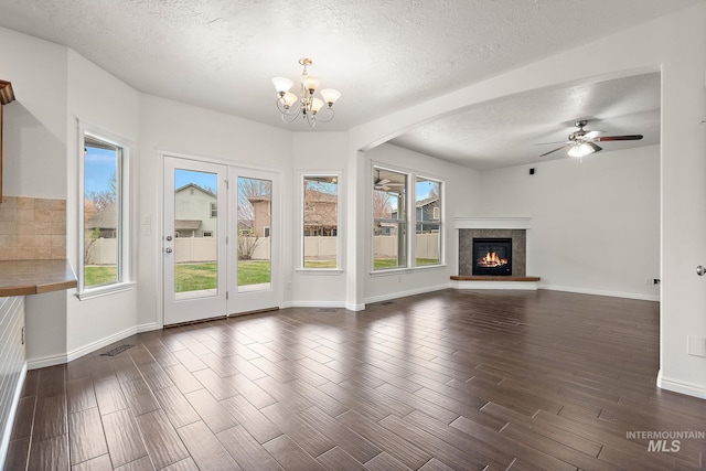 1452 E Pistioa, Meridian, ID 83642 - unfurnished living room with a textured ceiling, ceiling fan with notable chandelier, dark wood finished floors, and a glass covered fireplace