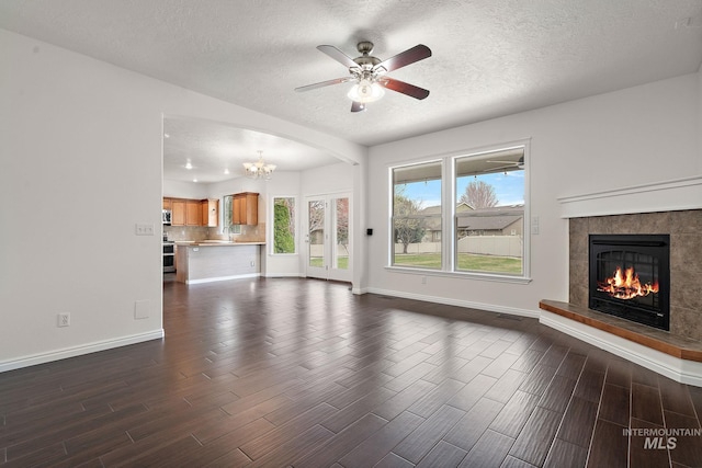 1452 E Pistioa, Meridian, ID 83642 - unfurnished living room featuring a fireplace, dark wood-style flooring, baseboards, and a textured ceiling