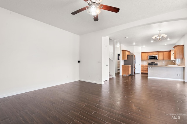 1452 E Pistioa, Meridian, ID 83642 - unfurnished living room featuring baseboards, a sink, ceiling fan with notable chandelier, and dark wood-type flooring