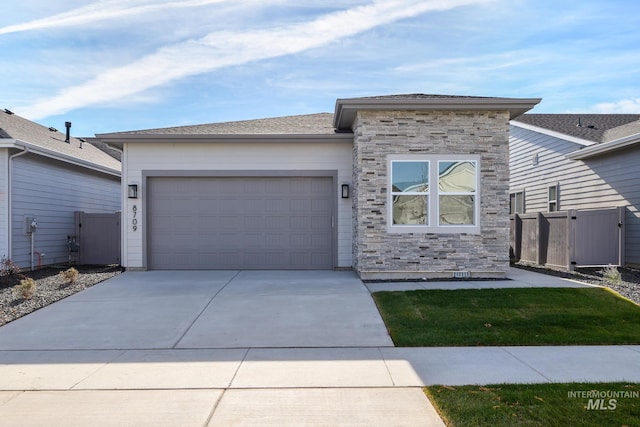 8709 W Pickett Creek St, Star, ID 83669 - view of front of house with stone siding, driveway, an attached garage, and a gate