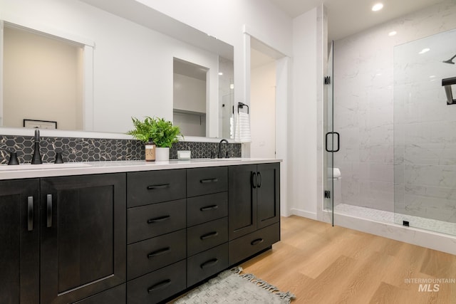 8709 W Pickett Creek St, Star, ID 83669 - bathroom featuring wood finished floors, a stall shower, double vanity, backsplash, and recessed lighting