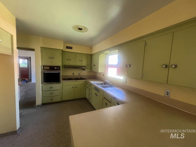 kitchen featuring sink, white gas stovetop, kitchen peninsula, oven, and green cabinetry