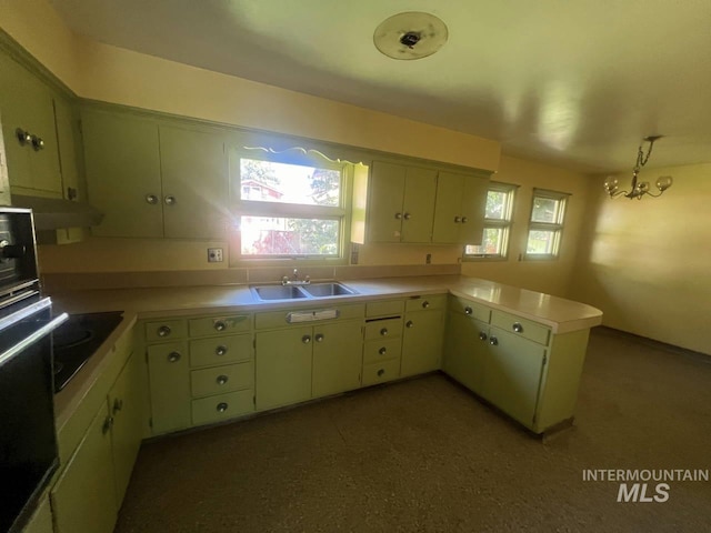 kitchen featuring black appliances, sink, green cabinetry, kitchen peninsula, and a chandelier