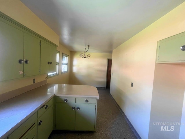 kitchen featuring kitchen peninsula, green cabinets, and a notable chandelier