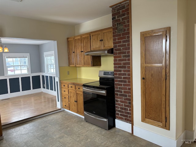 616 E 8th, Moscow, ID 83843 - kitchen featuring stainless steel electric stove, under cabinet range hood, a chandelier, brown cabinets, and light countertops