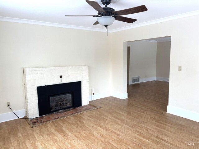 616 E 8th, Moscow, ID 83843 - unfurnished living room featuring light wood-style floors, crown molding, a fireplace, baseboards, and a ceiling fan