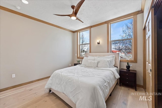 79 E Aikens Rd, Apt Eagle, ID 83616 - bedroom featuring a textured ceiling, light wood-style floors, ornamental molding, and ceiling fan
